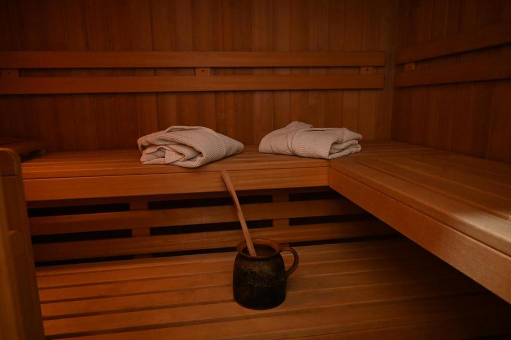 a sauna with two towels and a bucket in it at A Frame Vila sa Saunom Jakuzi kadom i toplim bazenom in Koraćica