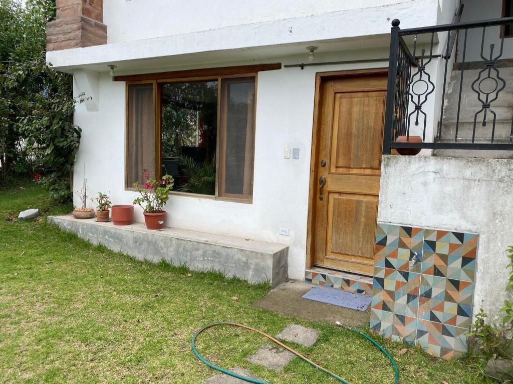 コタカチにあるCasa Blanca departamentoのドアの前にホースがある家