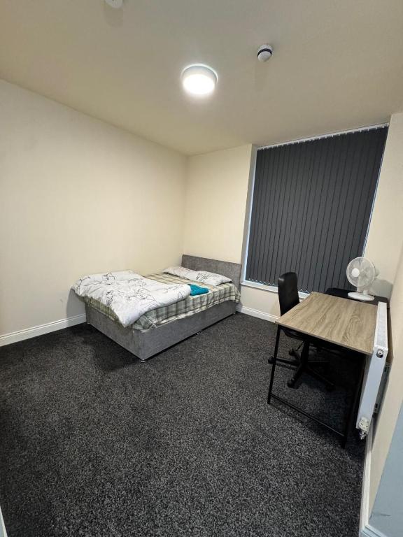 a bedroom with a bed and a desk in it at Barnsley Guesthouse Couple Room Ground Floor in Barnsley