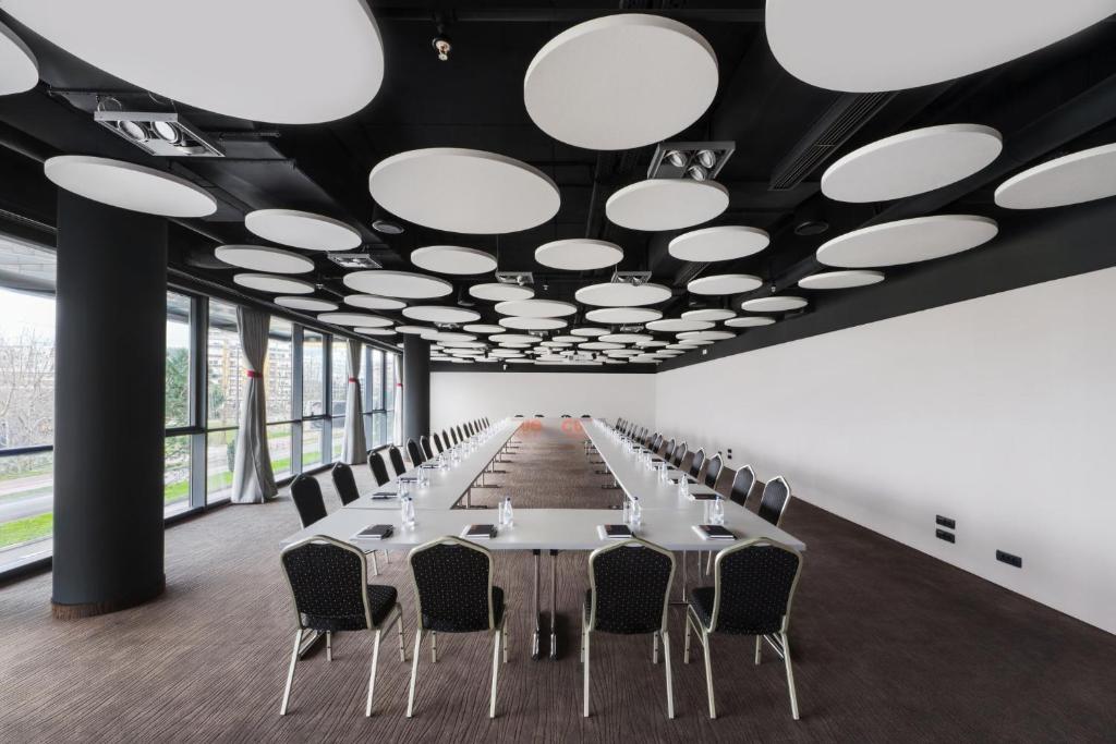 a long conference room with white tables and chairs at Crowne Plaza Podgorica by IHG in Podgorica