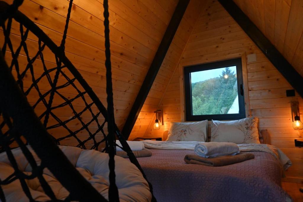 a bedroom with a bed in a wooden cabin at A Frame Vila sa Saunom Jakuzii i toplim bazenom in Koraćica