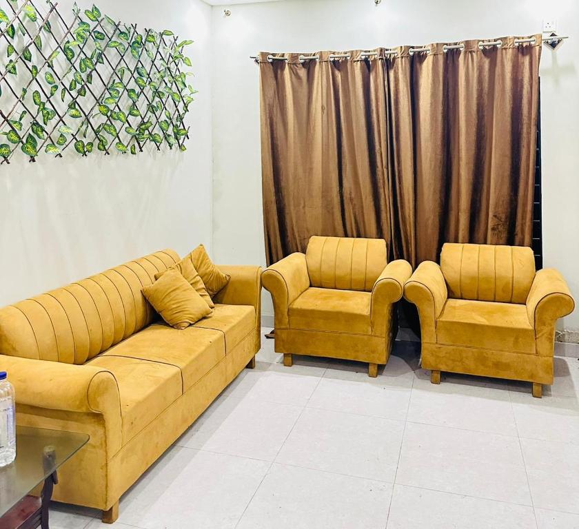 a living room with a couch and two chairs at Flat in wah cantt in Wāh