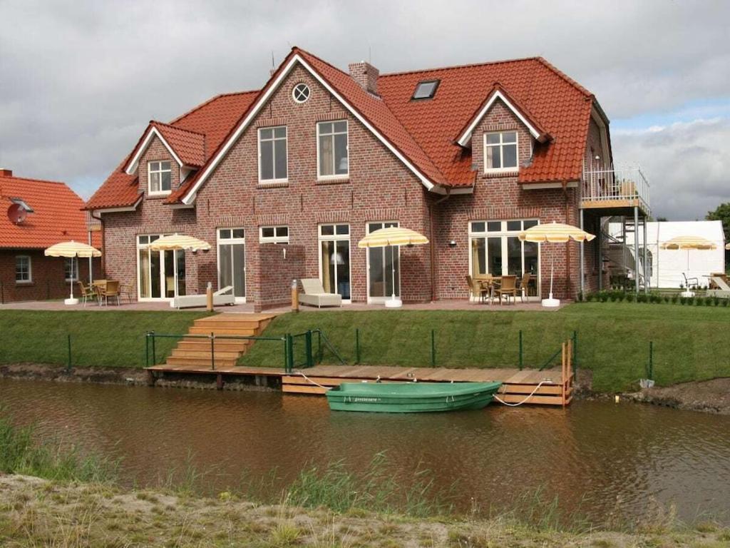 een huis met een boot op het water ervoor bij Twixlum - Greetsiel in Greetsiel