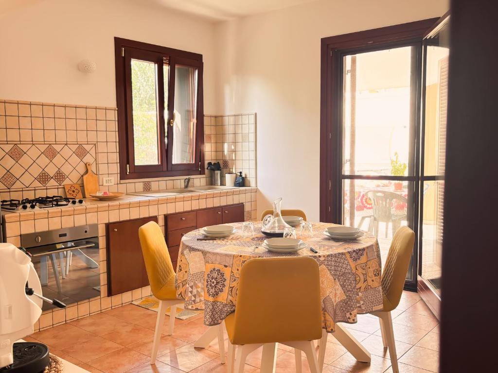 une cuisine avec une table, des chaises et un tissu de table dans l'établissement Dimora Lucci Marini, à Tarente