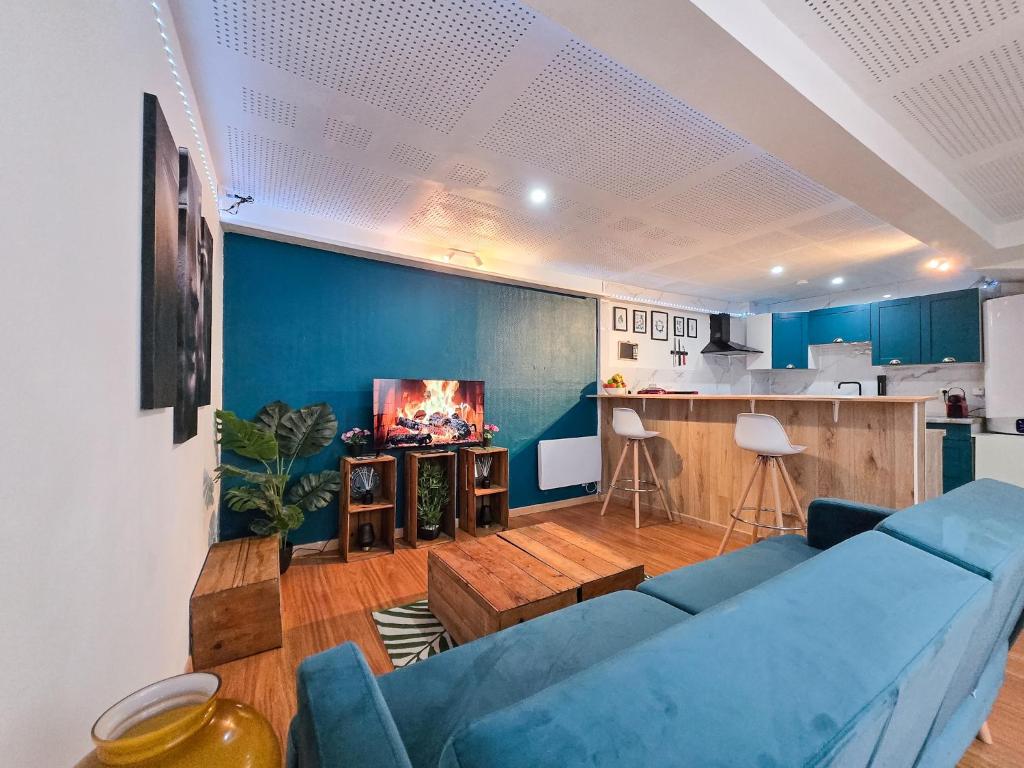 a living room with a blue couch and a kitchen at Duplex moderne au cœur de Saverne in Saverne