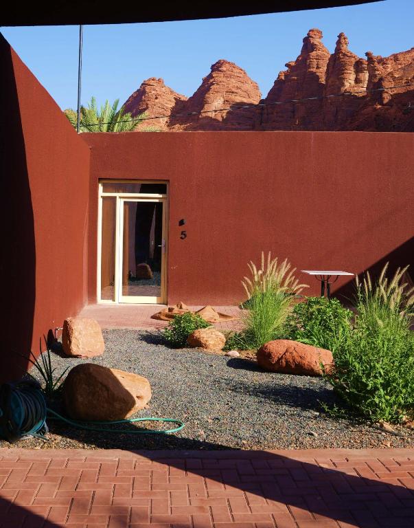 欧拉Wadi Sader的一栋红色的房子，前面有岩石