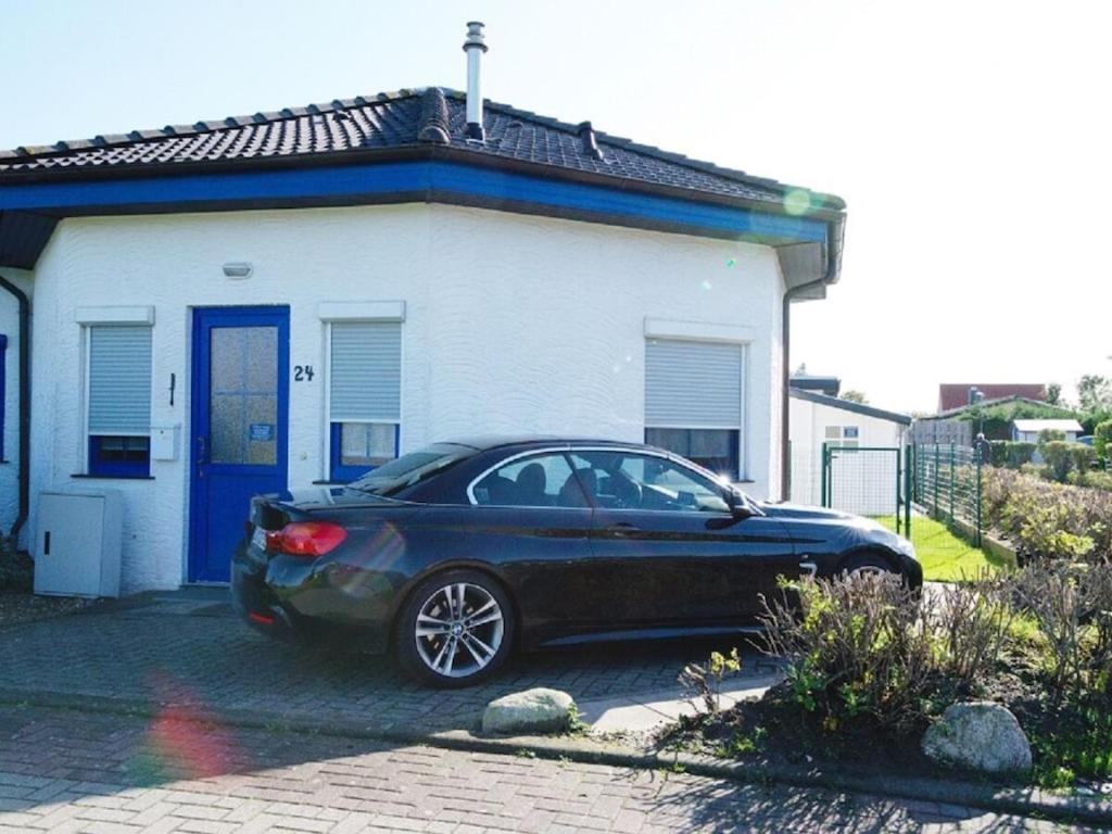a black car parked in front of a house at 1-bedroom holiday home in Dorum Neufeld