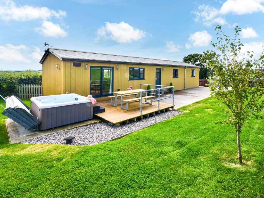 a small yellow house with a deck and a hot tub at 2 Bed in South Molton 78097 in South Molton