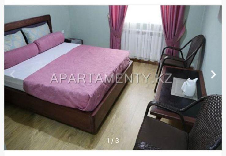 a bedroom with a large bed and a chair at Syr arna hotel in Tasbuget