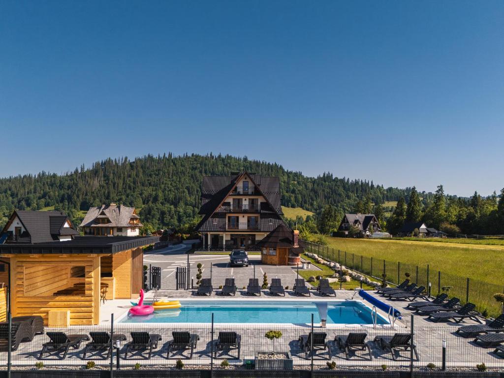 a resort with a pool and a house at Górska Grań in Poronin