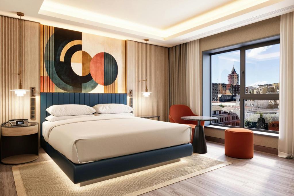 a bedroom with a bed and a large window at Delta Hotels by Marriott Istanbul Karakoy in Istanbul