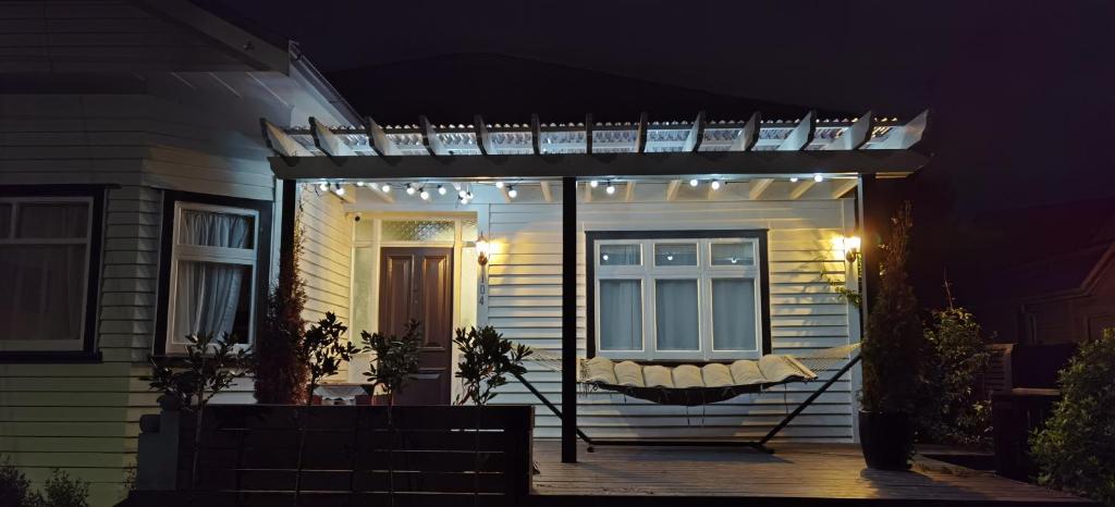 a pergola with lights on a house at night at Beautiful villa near everything! in Christchurch
