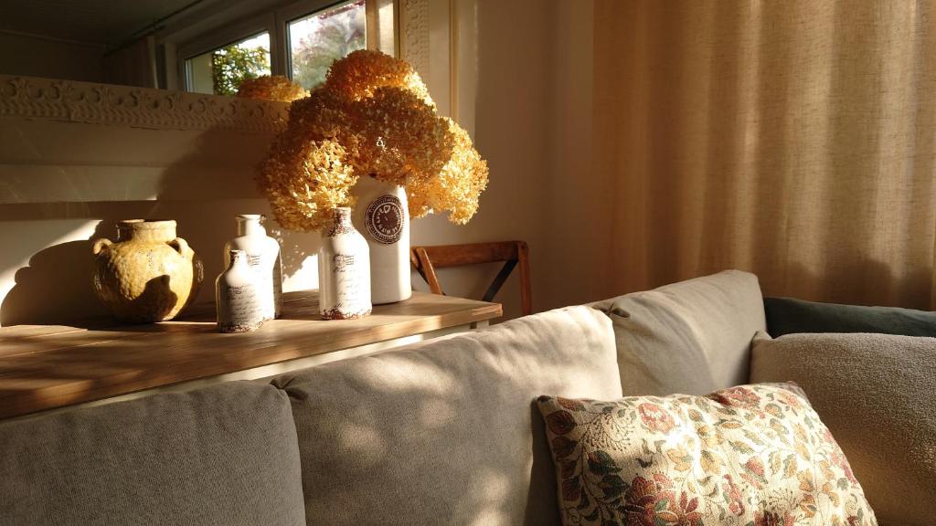 a living room with a table with a vase of flowers at Ferien am See in Möhnesee