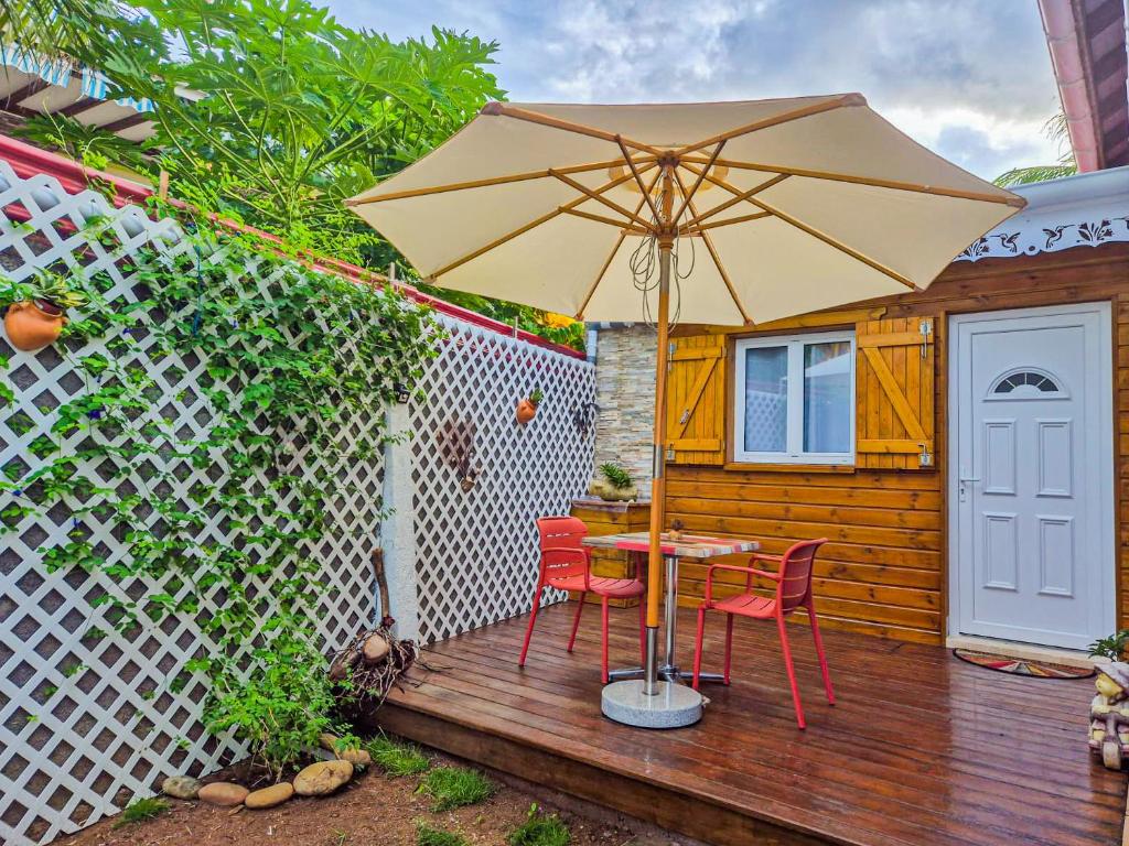 a patio with a table and two chairs and an umbrella at Chez didine in Terre-de-Haut