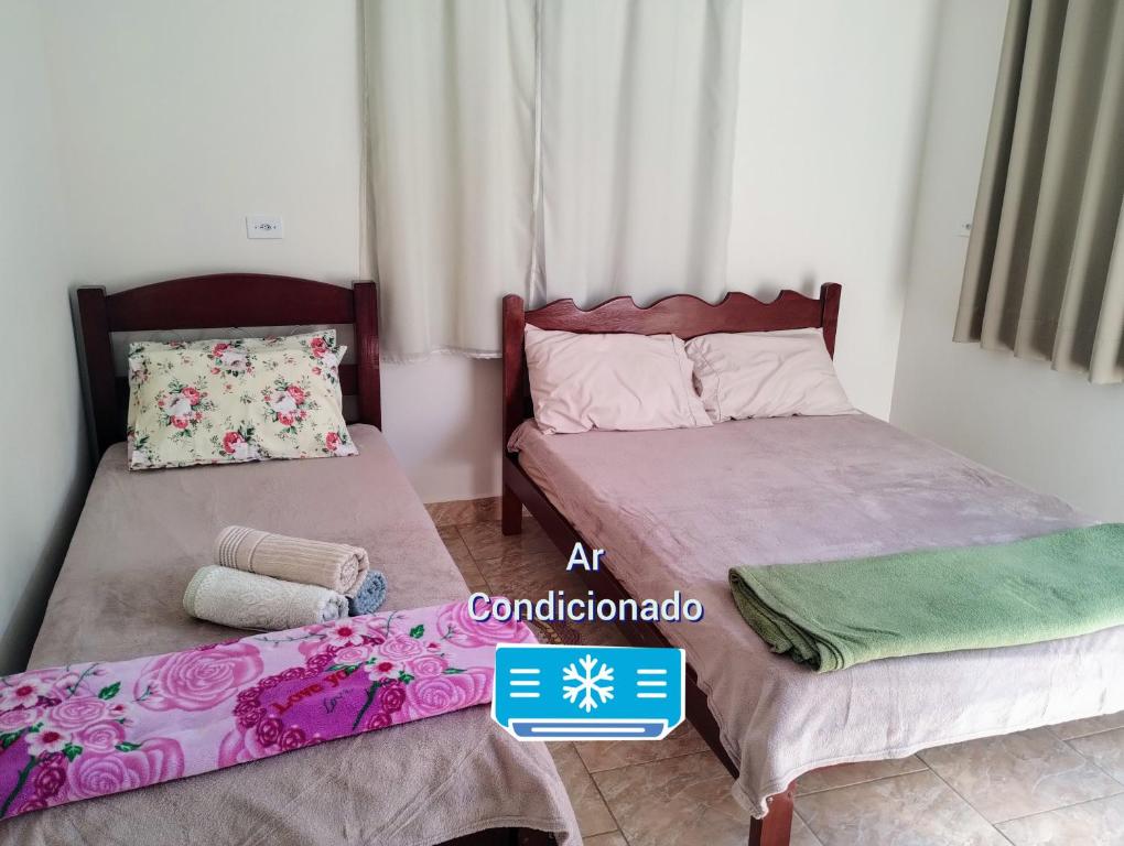 two beds in a small room with at Suíte separada da casa principal in São Pedro