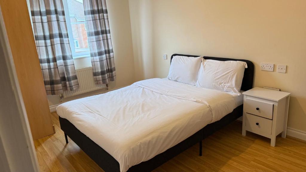 a bedroom with a bed with a night stand and a window at Wilmer House on Drum Road in Eastleigh