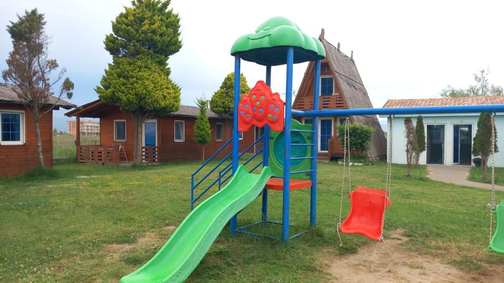 a playground with a slide in a yard at Shtepia Druri Sokol Lulaj in Lezhë