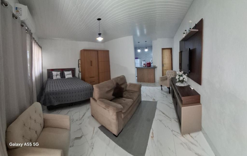 a living room with a couch and a bed at Apt estiloso in Sinop
