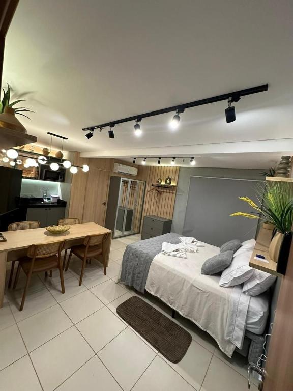 a bedroom with a bed and a table and a dining room at Diamante de Ribeirão Conforto e ótima localização! in Ribeirão Preto