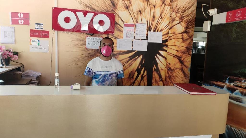 a man sticking his tongue out behind a counter at Hotel O PMR Near Ascendas Park Square Mall in Bengaluru