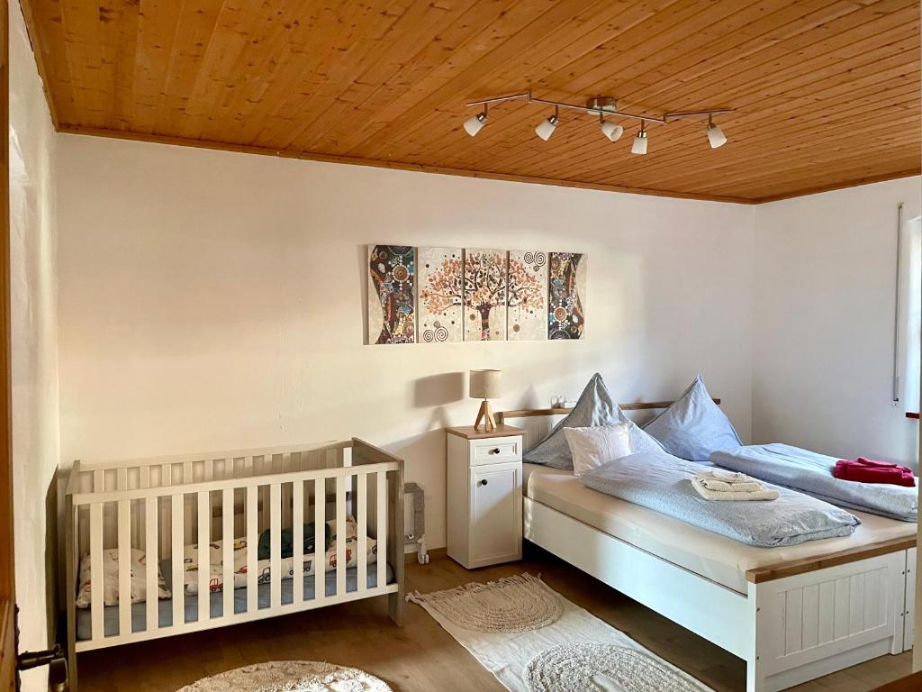 a baby bedroom with a crib and a ceiling at Altmuehl Familienvilla in Treuchtlingen