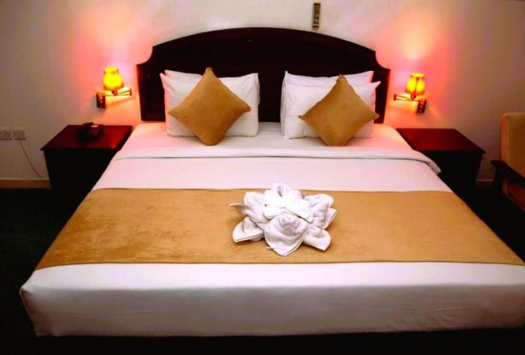 a bedroom with a bed with a flower on it at Ibri Oasis Hotel in Ibri