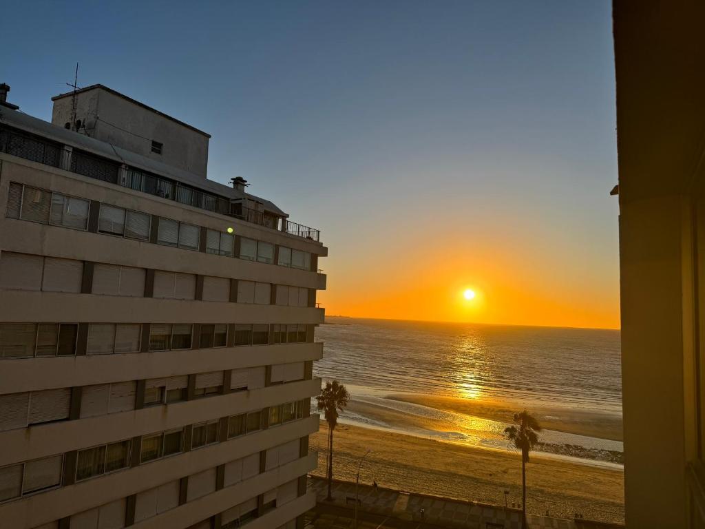 Apartamento en POCITOS vista al mar في مونتيفيديو: غروب الشمس من شرفة الفندق