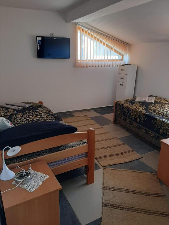 a bedroom with two beds and a tv on the wall at Vila Kostadinovic in Pirot