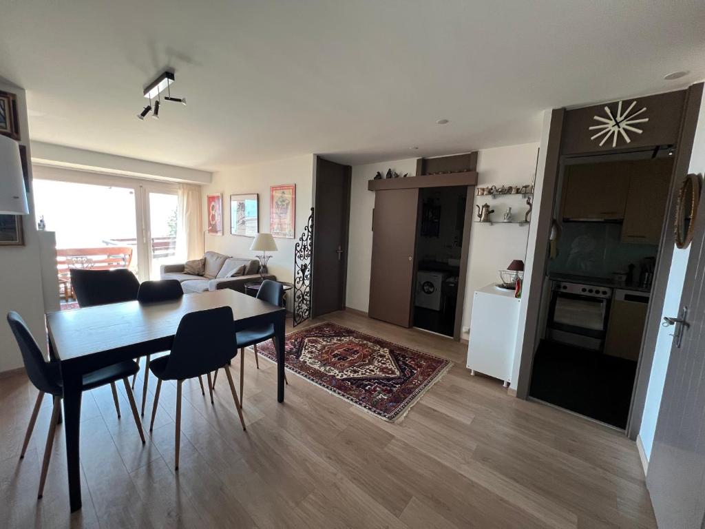 een woonkamer met een eettafel en een keuken bij Cozy apartment with stunning view in Anzère