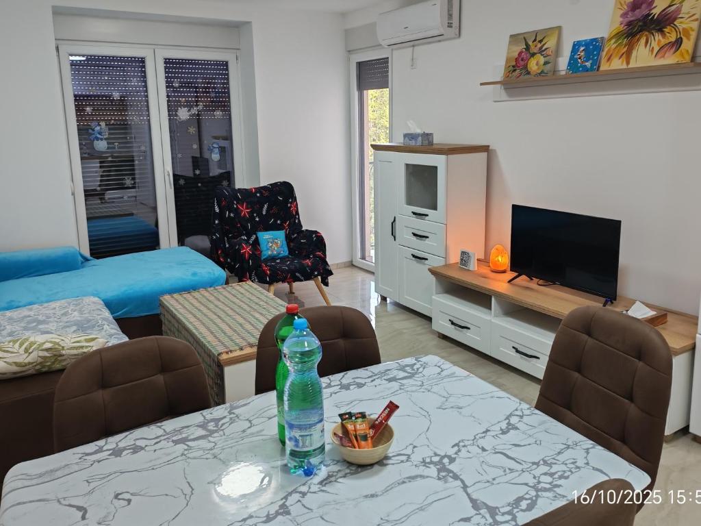 a living room with a table with a bottle on it at Sara apart in Pojate