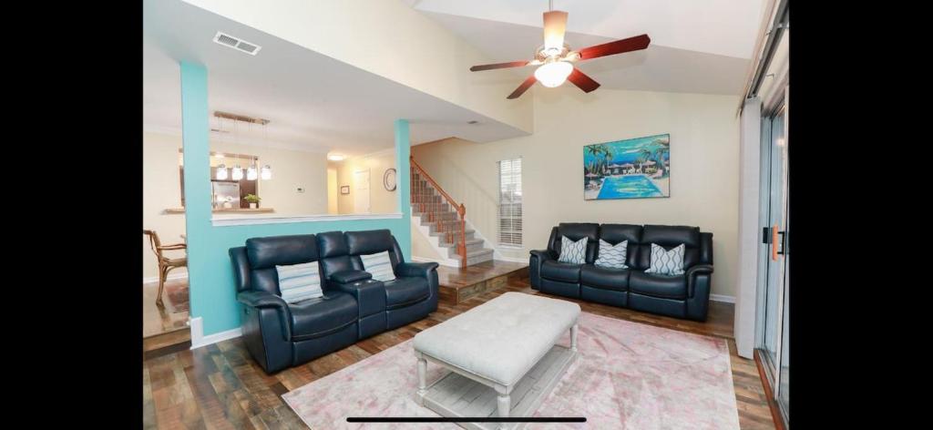 a living room with black leather furniture and a ceiling fan at MidLongTerm Rntal Comfy Home Away Near VA Beach in Virginia Beach