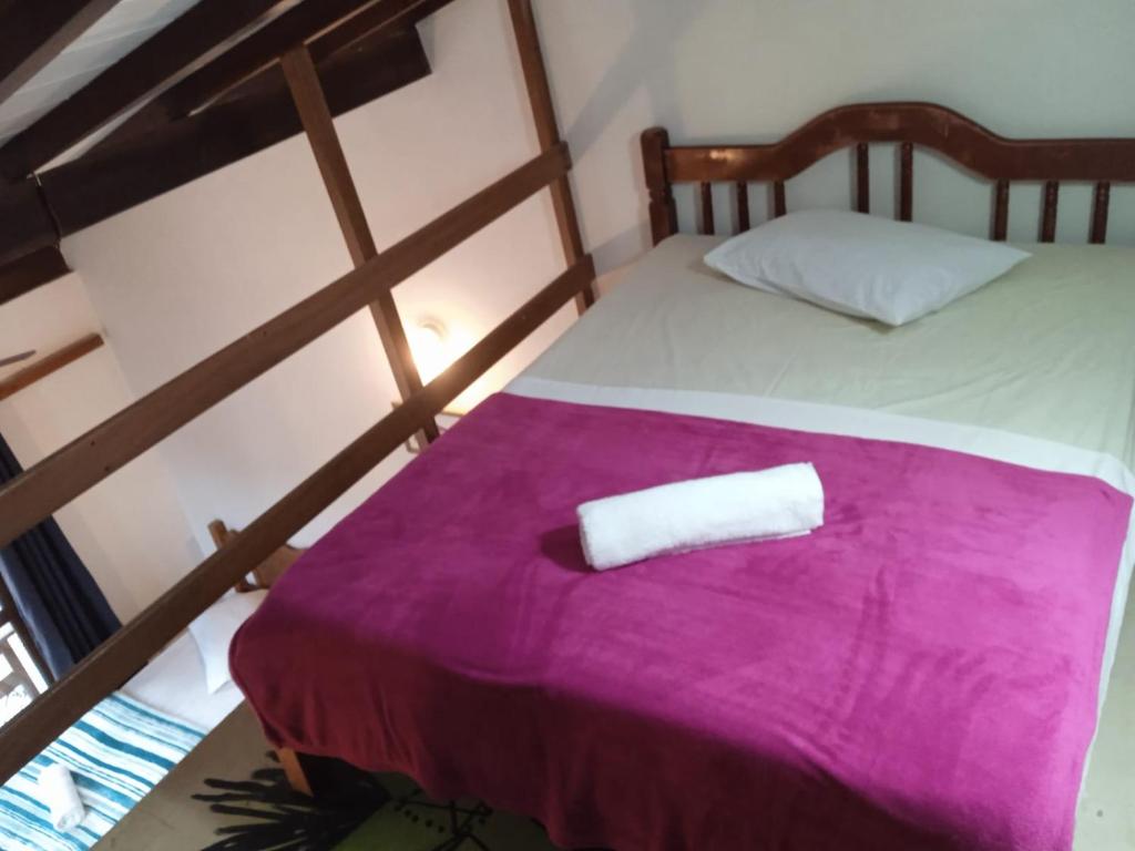 a bedroom with a bed with a towel on it at Casa Soul Green in Paraty