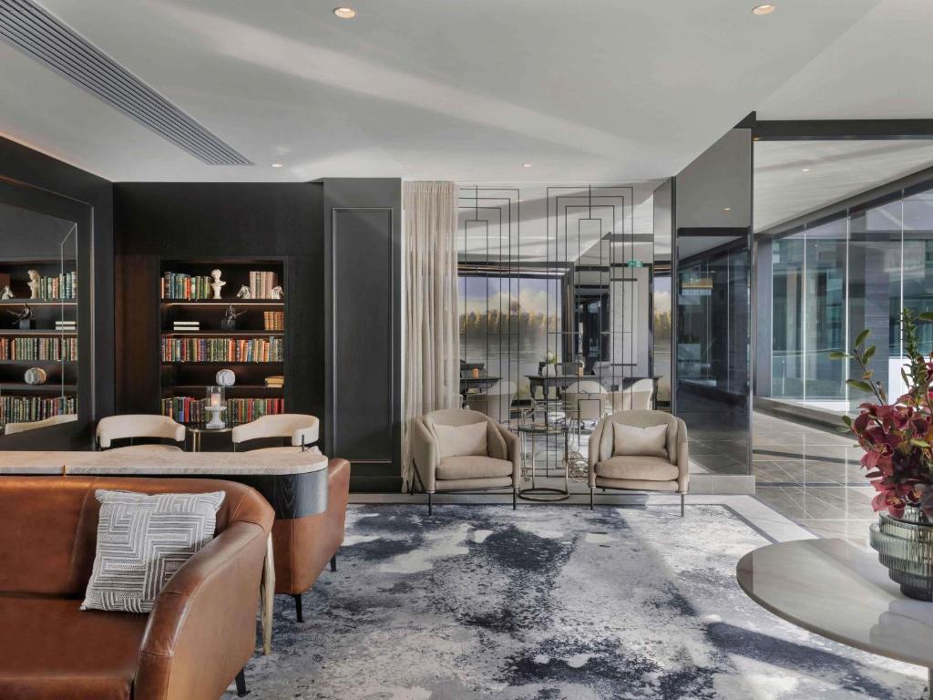 a living room with a couch and chairs and a table at Sofitel Auckland Viaduct Harbour in Auckland