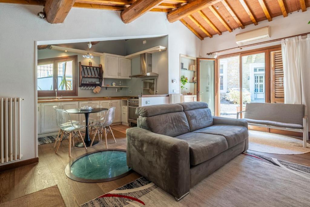 a living room with a couch and a kitchen at Small Villa with parking in Florence