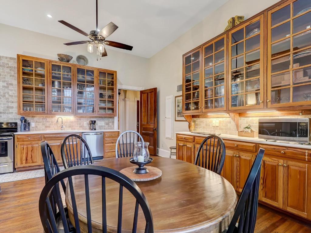 a kitchen with wooden cabinets and a wooden table and chairs at Parlor on Lafayette in Savannah