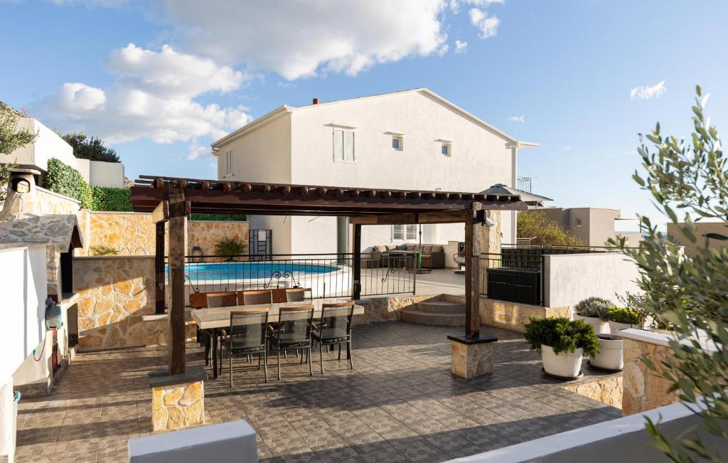 a patio with a table and chairs and a pool at Amazing Home In Makarska in Veliko Brdo