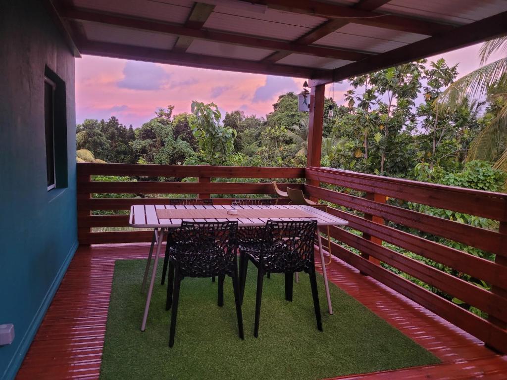 a table and chairs on a balcony with a view at Ti cocon nature in Sainte-Anne