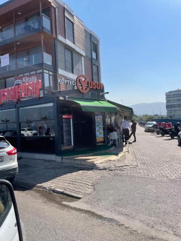 a building with a sign on the side of a street at Şehrin merkezinde evinizde hissedeceğiniz oda in Konak