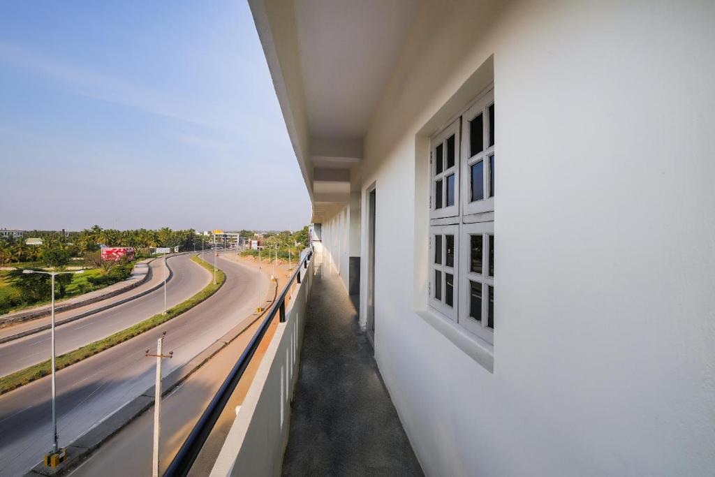 a white building with a view of a street at Hotel O Narayani Residency in Mysore
