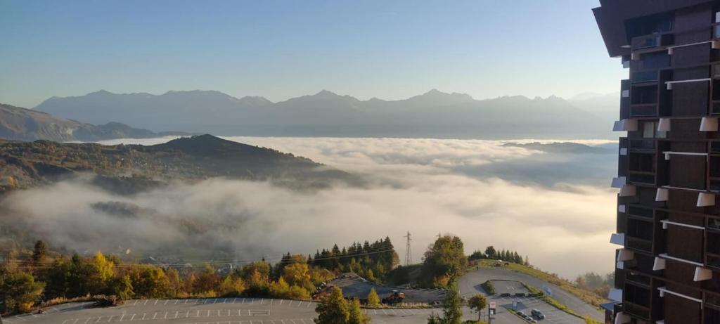 a view of a foggy valley in the mountains at appartement cozy au pied des pistes in Le Corbier