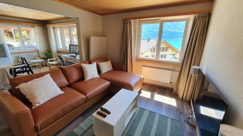 OberriedにあるApartment by Lake Brienz with lake viewのリビングルーム(ブラウンソファ、テーブル付)