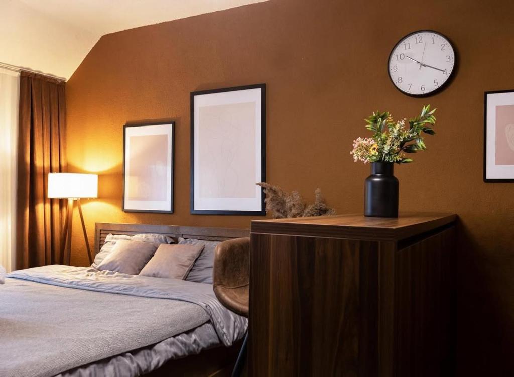 a bedroom with a bed and a clock on the wall at Prime space in Pristina