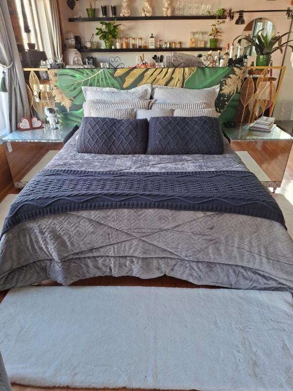 een groot bed met kussens in een kamer bij La Luciolla Loft Cabana in São Marcos