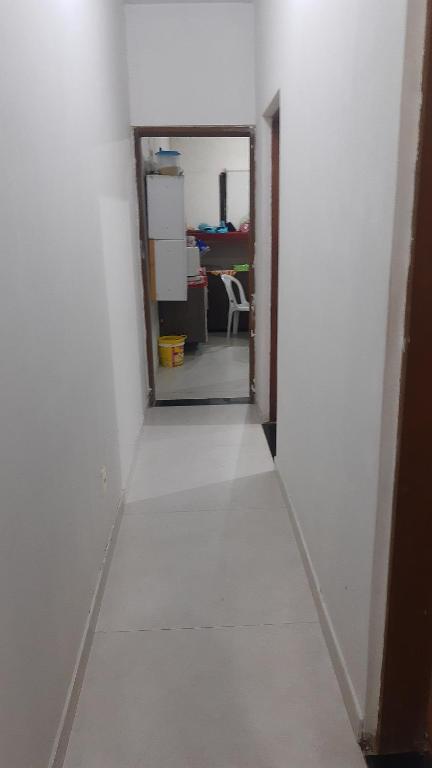 un pasillo con una pared blanca y un espejo en Pousada Luanda, en Peruíbe