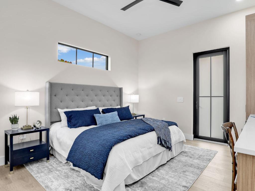 a bedroom with a large bed with blue pillows at Elegant Naples Studio with Huge Bathroom in Naples