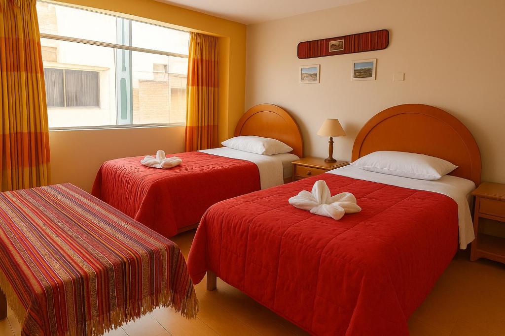 プーノにあるHOSTAL ACUARIUS PUNOのホテルルーム ベッド2台(弓付)