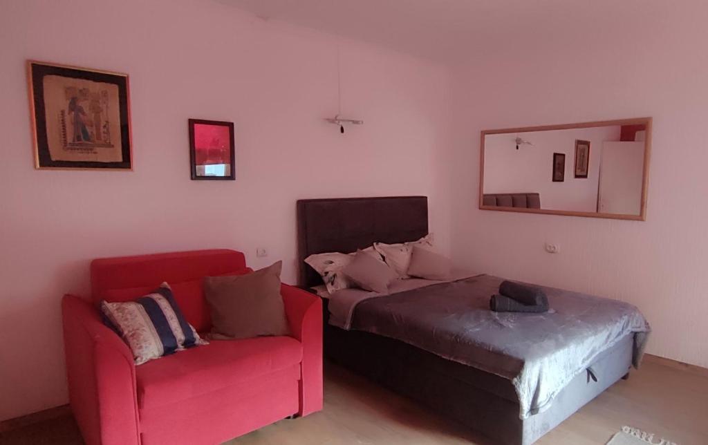 a bedroom with a couch and a bed and a chair at Republic square apartment in Belgrade