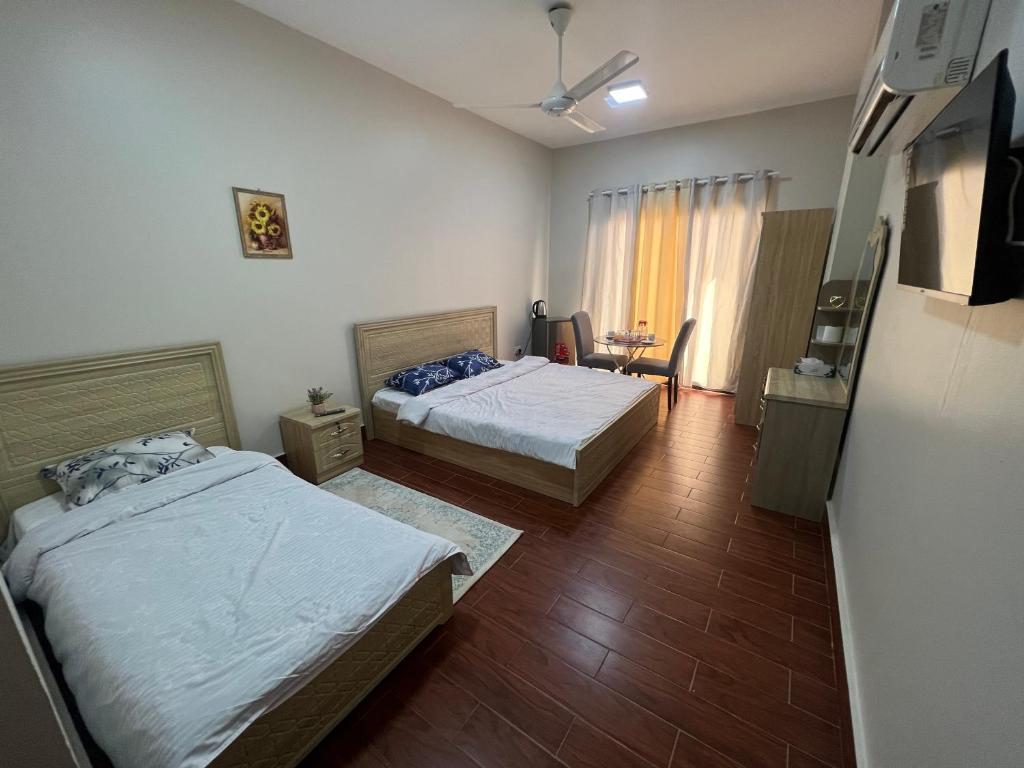 Una habitación de hotel con dos camas y un televisor. en AFAQ vip, en Mascate