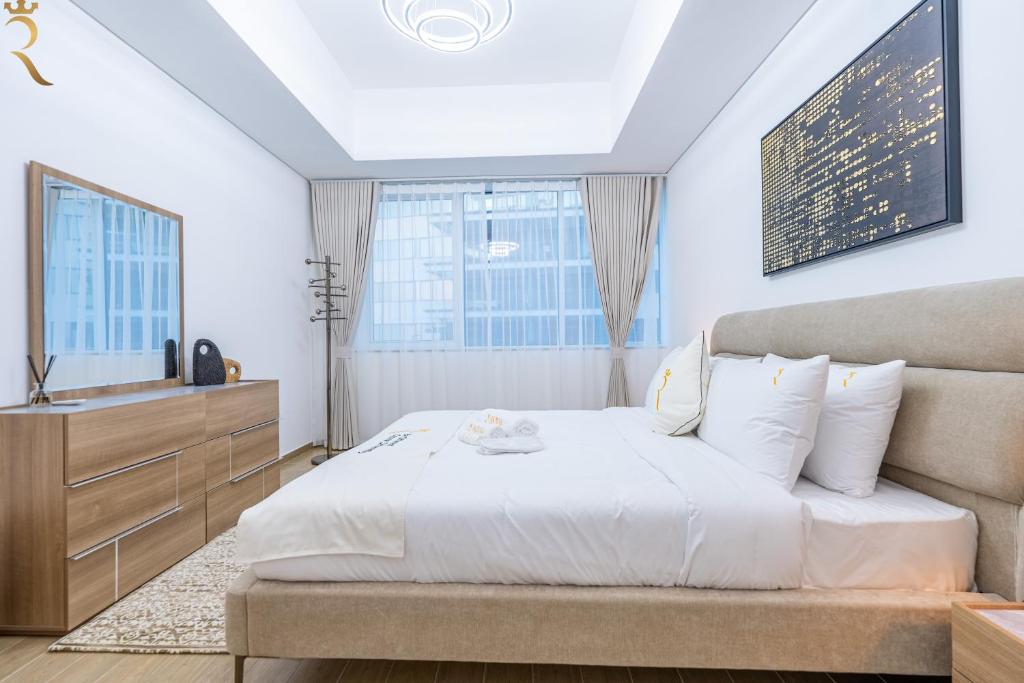 a bedroom with a large bed and a sink at Maison 2BR Mayan within 10 Min to Grand Prix in Abu Dhabi