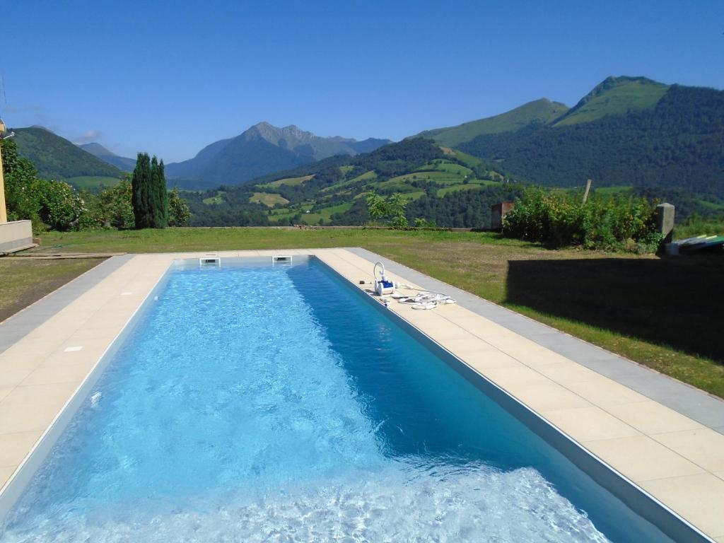 uma piscina com montanhas ao fundo em La Ferme aux Sangliers - Micalet em Issor